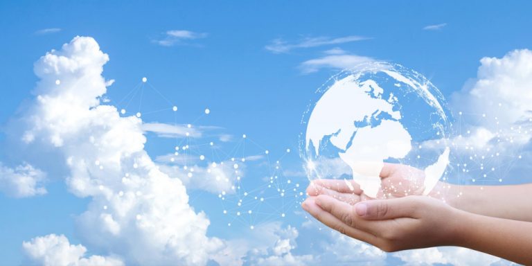Imagem de globo terrestre sendo segurado por duas mãos. Céu azul ao fundo. Montagem traz símbolos de rede, imagem representa os desafios das emergências climáticas e da pauta ESG crescentes.